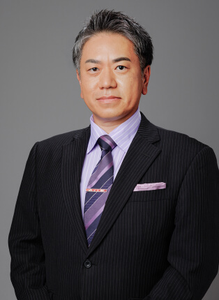 山本理の写真。正面を向きスーツを着用している。